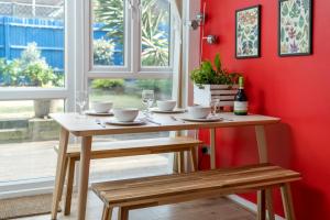 uma mesa num quarto com uma parede vermelha em ALTIDO Striking flat with charming garden em Londres