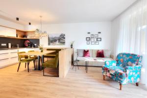 cocina y sala de estar con mesa y sofá en Alpenstolz Damüls Haus 4 - Stilvoll urlauben in den Bergen en Damuls