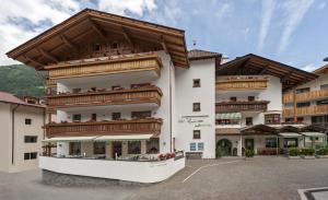 a large building with balconies on the side of it at Hotel Pfandleralm in San Martino