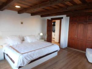 a bedroom with a large white bed and wooden cabinets at Atlantic paradise in Los Realejos