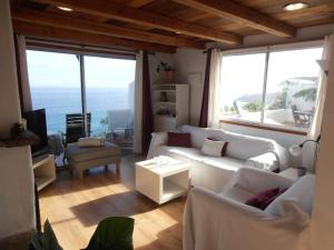 a living room with white furniture and large windows at Atlantic paradise in Los Realejos