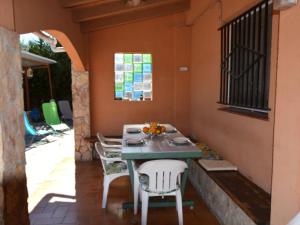 una mesa y sillas en un patio con ventana en Villa Brigitte private pool 10 kms LLoret de mar, en Maçanet de la Selva