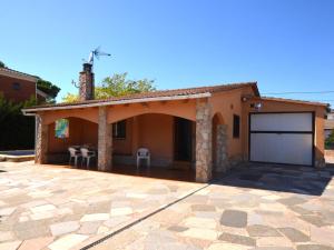 a house with a garage and a patio at Villa Brigitte private pool 10 kms LLoret de mar in Maçanet de la Selva