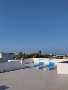 zwei blaue Stühle und ein Tisch auf dem Dach in der Unterkunft Villa Thomas BB in Ischia