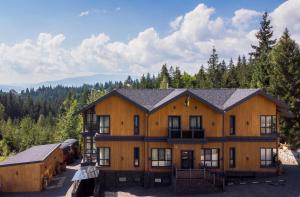 an aerial view of a large wooden building with trees at Ego Hotel Буковель in Yablunytsya