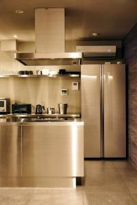 una cocina con nevera de acero inoxidable y armarios en 634 Condo Shinjuku - Vacation STAY 14798v, en Tokio
