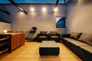 ein Wohnzimmer mit einem Sofa, Stühlen und einem Tisch in der Unterkunft 634 Condo Shinjuku - Vacation STAY 14798v in Tokio