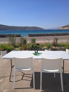 ein weißer Tisch und Stühle mit Blick auf den Strand in der Unterkunft Studios Melusine in Limenas Thasou