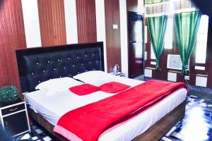 a bedroom with a large bed with a red blanket at Flagship Corbett Farm Homestay in Rāmnagar