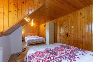 1 dormitorio con 2 camas en una cabaña de madera en Cabana Râușor, en Cîmpulung
