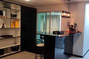 a kitchen with a black island in a room at Baln Piçarras-Bally Beach Club Beira Mar in Piçarras