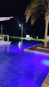 a swimming pool with blue and purple lights at Baln Piçarras-Bally Beach Club Beira Mar in Piçarras
