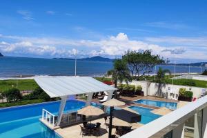 a swimming pool with a view of the ocean at Baln Piçarras-Bally Beach Club Beira Mar in Piçarras