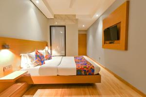 a bedroom with a bed and a tv on a wall at FabHotel Penthouse in Guwahati