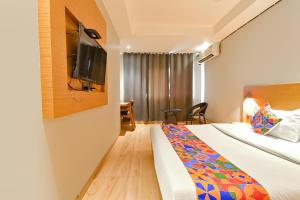 a hotel room with a bed and a tv at FabHotel Penthouse in Guwahati