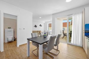 ein Esszimmer und eine Küche mit einem Tisch und Stühlen in der Unterkunft Apartments Tim & Klara - Sunny Cres Island in Cres
