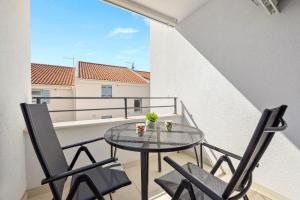a balcony with a glass table and two chairs at Apartments Tim & Klara - Sunny Cres Island in Cres