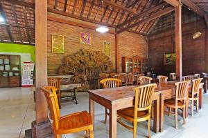 a dining room with a wooden table and chairs at Super OYO 3693 Kopi Klotok Homestay Syariah in Magelang