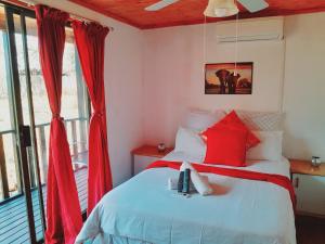 a bedroom with a bed with red curtains at Igula lodge in Mkuze