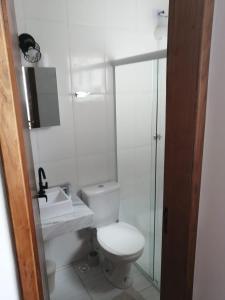 een witte badkamer met een toilet en een wastafel bij Sobrado Pontal Santa Marina in Caraguatatuba