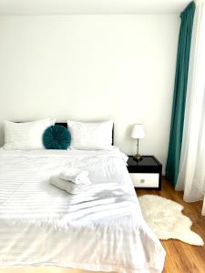 a white bed with white sheets and pillows on it at Scandinavia Apartament in Piatra Neamţ