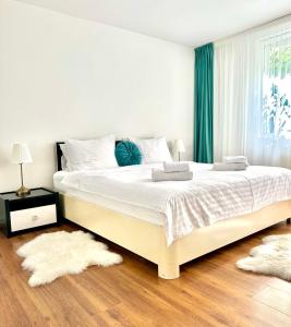 a bedroom with a large white bed with green curtains at Scandinavia Apartament in Piatra Neamţ
