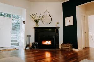 a living room with a fireplace and a mirror at Mistwood - Pet Friendly in Mount Macedon