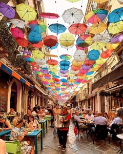 un groupe de parapluies suspendus à un plafond dans une rue dans l'établissement Casa Gisira, à Catane