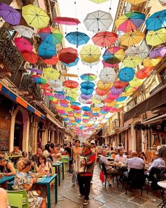 a group of umbrellas hanging from a ceiling in a street at Casa Gisira in Catania
