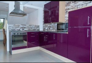 a kitchen with purple cabinets and a microwave at Unter den Sternen in Bottrop