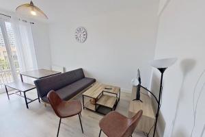 een woonkamer met een bank, stoelen en een tafel bij F4 - La Maison de M. Goéland in Le Havre