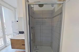 La salle de bains est pourvue d'une douche avec une porte en verre. dans l'établissement F4 - La Maison de M. Goéland, au Havre