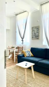 a living room with a blue couch and a table at Chez Clement et Mathilde - T2 hyper centre tout équipé in Saint-Amand-les-Eaux