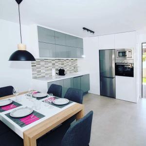 a kitchen with a dining table with chairs and a kitchen with appliances at les temps heureux in Alger