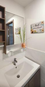 La salle de bains est pourvue d'un lavabo blanc et d'un miroir. dans l'établissement Seaview Regalia Park, (Happy House), Full Furnished, Free WiFi Forestcity, à Gelang Patah