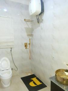 a bathroom with a toilet and a sink at Somewhere Apartment in Gwarinpa