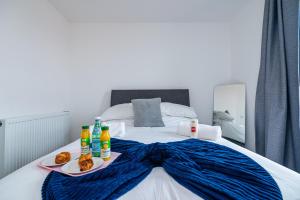 a bed with two plates of food and drinks on it at K Suites - 585 London Road in Colnbrook