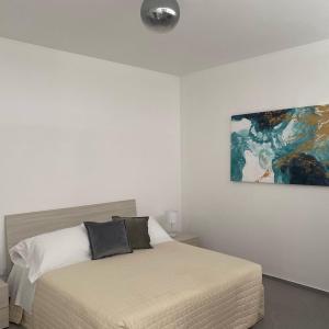 una camera da letto con un letto e un dipinto sul muro di Il Mare di Giù Boutique Guesthouse a Licata