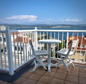 einen Tisch und Stühle auf einem Balkon mit Blick auf das Wasser in der Unterkunft Apartamento con vistas Sada (saudade) in Sada