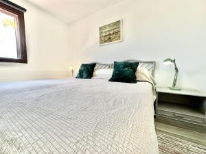 1 dormitorio blanco con 1 cama grande con almohadas azules en Poolside Villa, Golf del Sur, en San Miguel de Abona