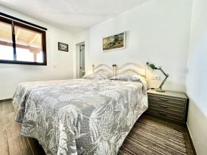 een slaapkamer met een bed en een lamp op een dressoir bij Poolside Villa, Golf del Sur in San Miguel de Abona
