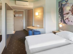 ダルムシュタットにあるB&B ホテル ダルムシュタットのベッド2台とデスクが備わるホテルルームです。