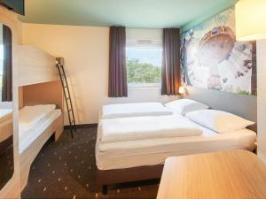 una camera d'albergo con due letti e una finestra di B&B Hotel Darmstadt a Darmstadt