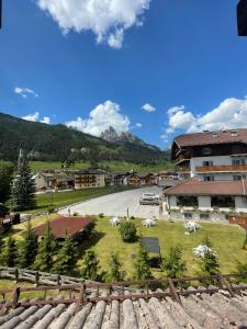 a view of a town with animals in the grass at Appartamento Monzoni in Pozza di Fassa