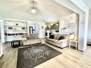 una sala de estar con 2 sofás y una alfombra en Poolside Villa, Golf del Sur, en San Miguel de Abona