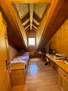 a small room with a bed in a attic at Appartamento Monzoni in Pozza di Fassa