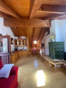 a living room with a red couch and wooden ceilings at Appartamento Monzoni in Pozza di Fassa