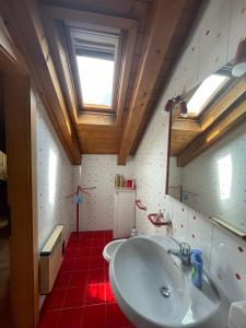 a bathroom with a white sink and a window at Appartamento Monzoni in Pozza di Fassa