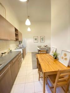 eine Küche und ein Esszimmer mit einem Holztisch in der Unterkunft Sziv Apartment - Modern and Comfortable in Budapest