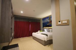 a bedroom with a bed and a red curtain at KRABI CHARM in Ban Khlong Haeng